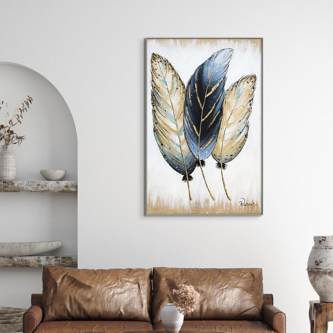 Framed feather canvas painting above a brown sofa — Sona Casa