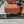 Two orange cushions on a chair with a marble floor and store interior in the background